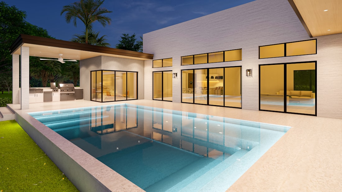 Hollywood Hills villa lit at night with a glowing swimming pool and terrace