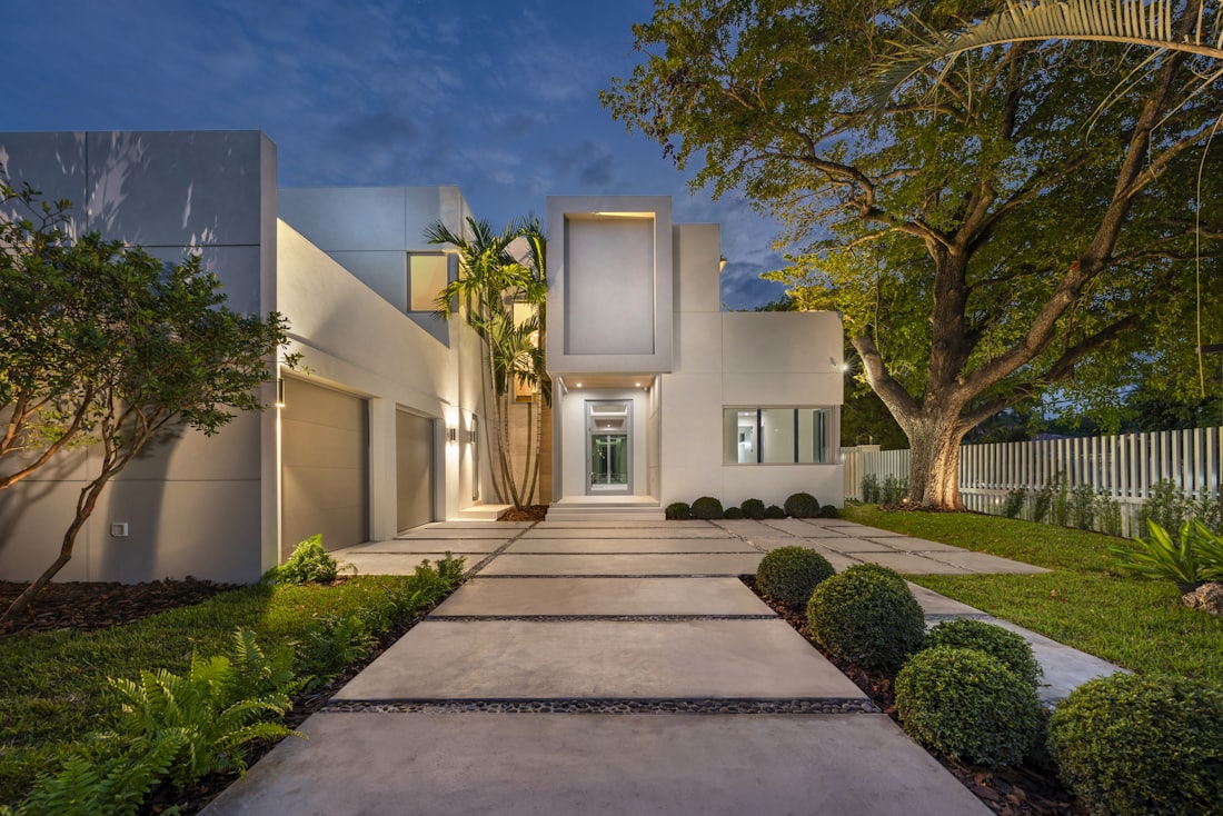 Austin modern family home at dusk with lit pool and landscaped lawn